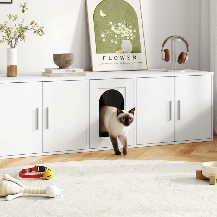 White pet furniture with a cat peeking out, placed in a room with decor elements.